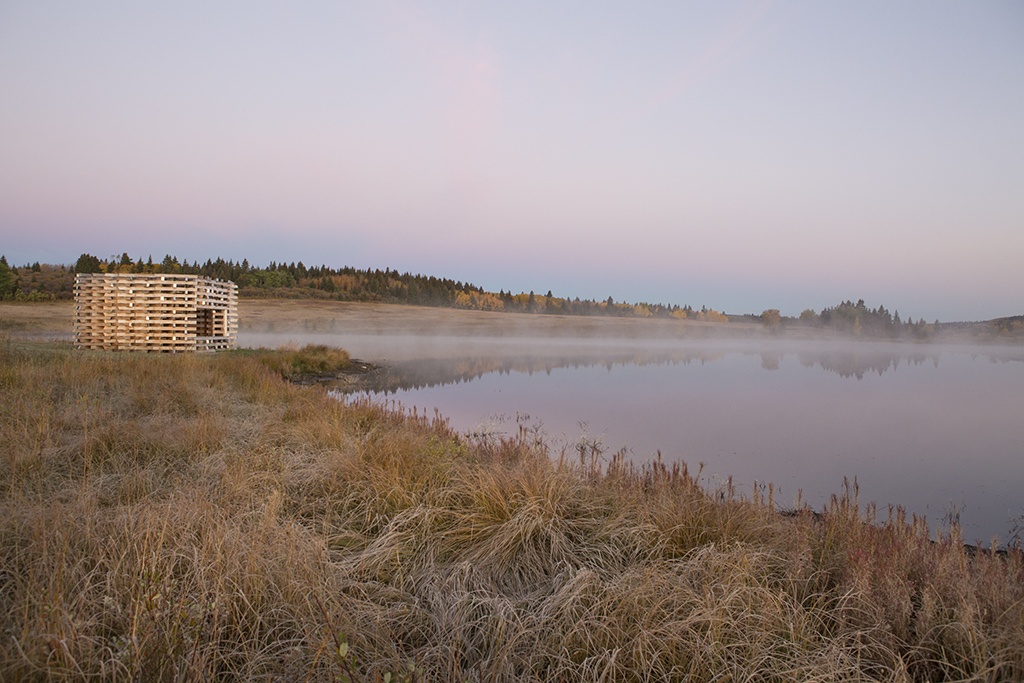 The Carraig Ridge Fire Place at sunrise; Anna Lake reflecting the pinks and purples of a cloudless pastel sky