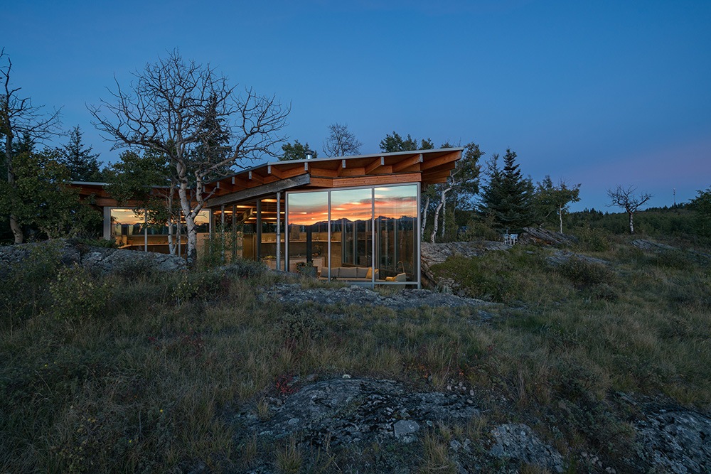 At night, the Rock House glazing reflects the Rocky Mountains