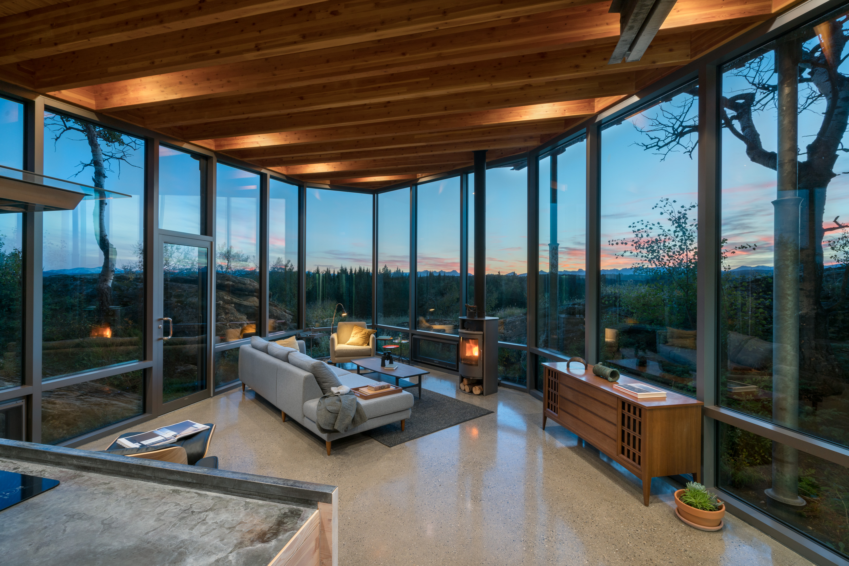 The glass wall of the living room of the Rock House was designed by James Cutler to perfectly follows the natural rock outcropping.